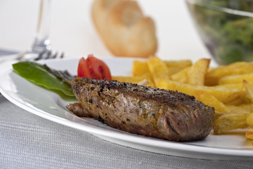 Rindersteak mit Pommes frites auf einem weißen Hintergrund