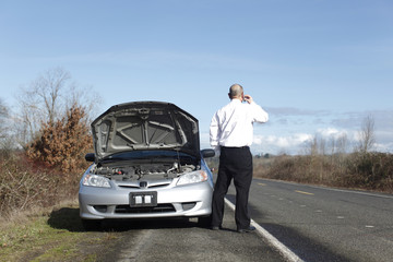 Businessman on cellphone with car trouble
