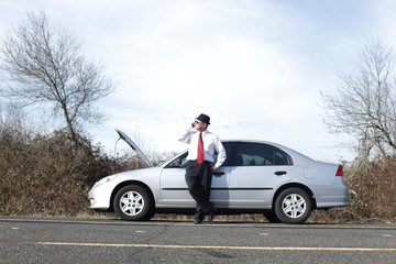 Businessman on cellphone with car trouble