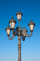 Fototapeta na wymiar Old fashioned street lamp over blue sky