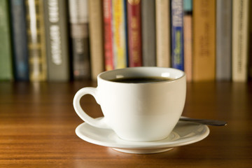Coffee and books on a wooden table. Small depth of sharpness.