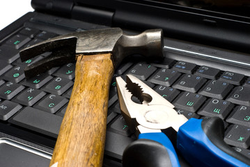 hammer and pliers on a laptop