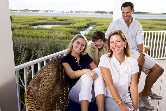 Family on vacation sitting together on terrace