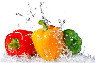 red, yellow and green pepper with water splash isolated on white