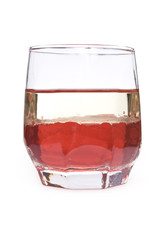 glass with red liquid and layer of oil