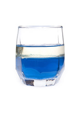 glass with blue liquid and layer of oil