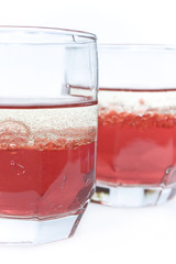 two glass with red liquid and bubbles of oil
