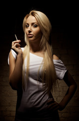 Obraz premium Portrait of young blond woman with a cigarette
