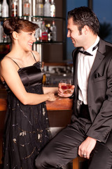 Young couple at bar drinking and flirting