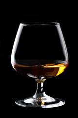 Snifter glass of cognac on black background.
