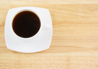 White cup of coffee on wooden background