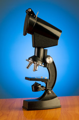 Microscope against blue gradient background