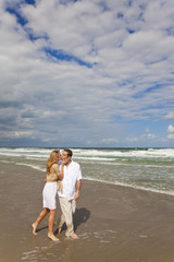 Man and Woman Couple Walking and Kissing On A Beach