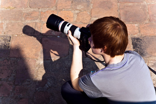 Fototapeta boy takes pictures with tele lens in temple area in Ajutthaya