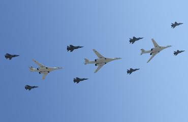 The group of planes flies against the dark blue sky