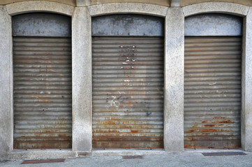 lowered rolling shutters of a disused shop