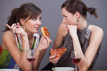 women with sparkling wine and pizzas