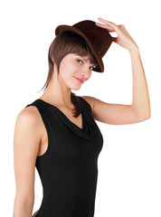 The young girl tries on a hat on a white background