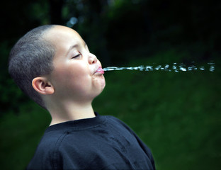 Latino boy spitting water