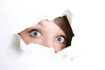 young girl peeping through hole in paper