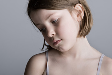 Sad Looking Child against a Grey Background