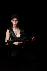 Fototapeta premium young and attractive woman holding an assault rifle