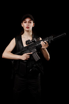 young and attractive woman holding an assault rifle