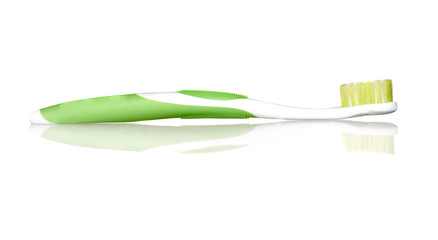 Green toothbrush with reflection on the floor