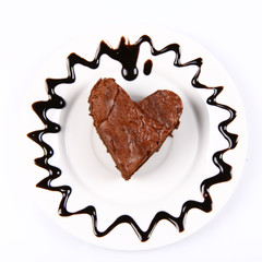 Heart shaped slice of a brownie on a plate and custard