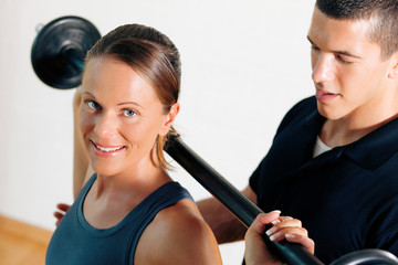 Trainer und Frau im Fitnessstudio