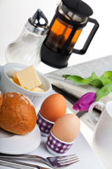 Eier, Brötchen, Butter und Kaffee auf weißem Hintergrund