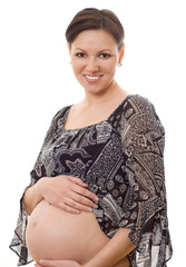 pregnant woman stands and smiles on a white background