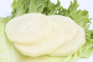 Slices of black radish wisth green salad