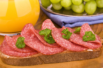 Brot belegt mit Salami und Petersilie