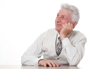 middle-aged businessman sitting pensively against a white backgr