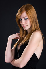 Fototapeta premium portrait of a shy redhead girl in black dress