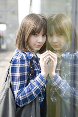 portrait of young serious teen girl outdoor  near glass wall