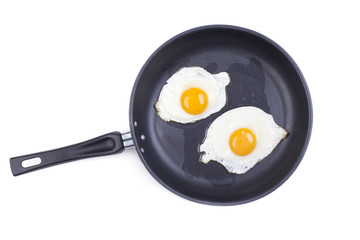 fried eggs in a frying pan on white background