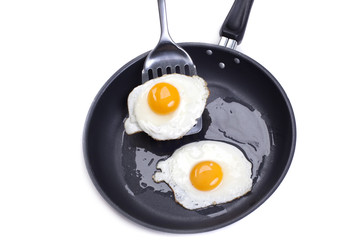 fried eggs in a frying pan on white background
