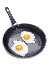 fried eggs in a frying pan on white background