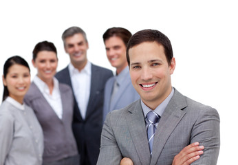 Smiling businessman with folded arms standing with his team