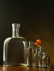 Empty old bottles, sepia tinted and flower