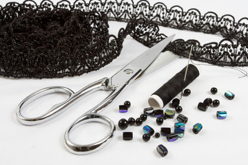 sewing background: metal scissors,black threads, lace, beads