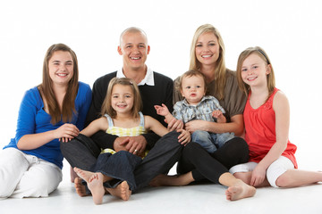 Shot Of Family Group Sitting In Studio