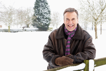 Senior Man Standing Outside In Snowy Landscape