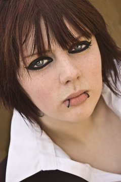 Attractive Young Woman With Lots Of Eyeliner And Lip Piercings