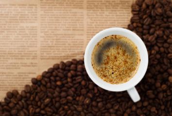Cup and Coffee Beans on newspaper backgroun