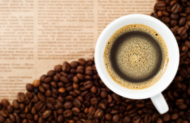 Cup and Coffee Beans on newspaper backgroun