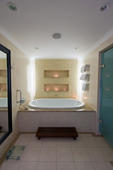 Luxury bathroom with large bath and lit candles