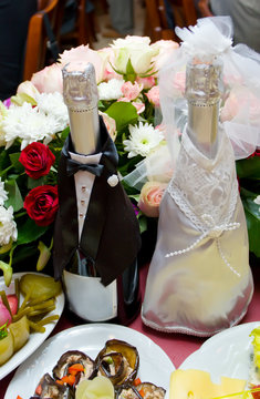Wine bottle decorated as newly-married couple on wedding